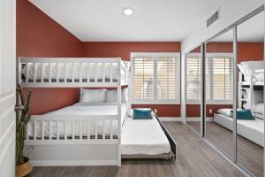two bunk beds in a room with red walls at The Modern Indio Large Family Home With Pool And Spa in Indio +36 photos