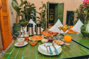Hotel & Riad Veridis في مراكش: طاولة عليها طعام ومشروبات للإفطار