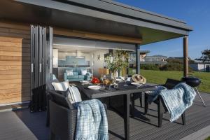 a patio with a table and chairs on a deck at Wavelength in St. Agnes