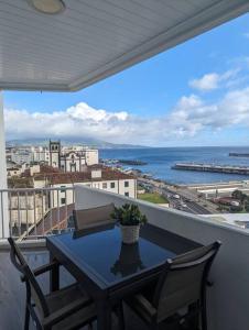 a table on a balcony with a view of the ocean at Bela Vista Solmar 3 B/R in Ponta Delgada