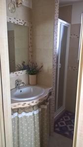 a bathroom with a sink and a shower with a mirror at Trulli della Catena in Martina Franca