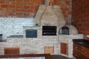 a brick oven in a kitchen with a brick wall at Chácara Família Batista in Mairiporã