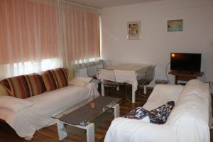 uma sala de estar com sofás brancos e uma mesa em City 2- room flat near uni and Limbecker Platz em Essen