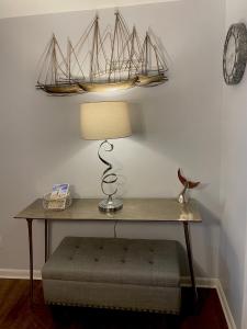 een tafel met een lamp en een klok aan een muur bij Smooth Sailing on Lake Waccamaw in Lake Waccamaw