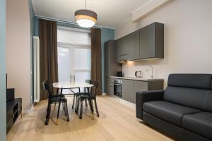 un soggiorno con divano e tavolo con sedie di Classbnb - 2 bilocali di design in zona Porta Garibaldi a Milano