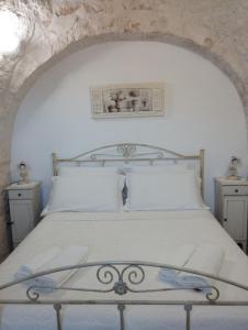 a bedroom with a white bed and two night stands at Trulli della Catena in Martina Franca