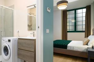y baño con cama y lavadora. en Classbnb - 2 bilocali di design in zona Porta Garibaldi, en Milán