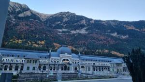 a large white building with mountains in the background at ssolivellasscanfranc in Canfranc-Estación