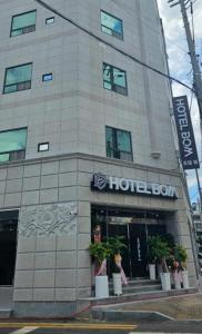 木浦的住宿－Hotel Bom，前面有盆栽植物的酒店大楼