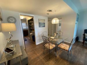 a dining room with a glass table and chairs at Smooth Sailing on Lake Waccamaw in Lake Waccamaw