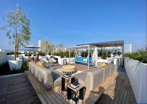 patio con divani e tavoli su una terrazza di Luxurious SM Penthouse with Panoramic Ocean Views a Los Angeles