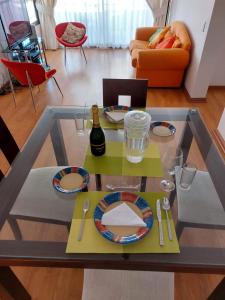 uma mesa de vidro com pratos e uma garrafa de vinho em Iquique em Iquique