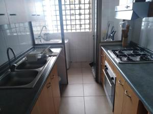 a kitchen with a sink and a stove top oven at Iquique in Iquique