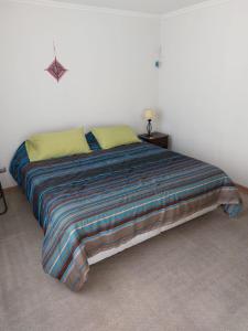 uma cama com um cobertor colorido num quarto em Iquique em Iquique