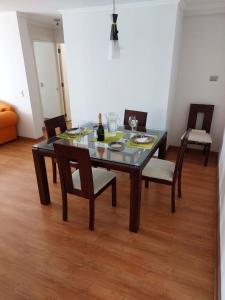 uma mesa de jantar com cadeiras e uma garrafa de vinho em Iquique em Iquique