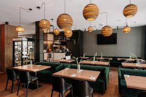 a restaurant with wooden tables and green booths at Hotel Saltic Resort & Spa Grzybowo in Kołobrzeg