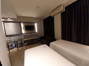 um quarto de hotel com duas camas e uma televisão de ecrã plano em Royal Golden Hotel - Savassi em Belo Horizonte