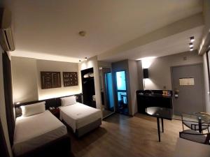 una camera d'albergo con due letti e un tavolo di Royal Golden Hotel - Savassi a Belo Horizonte