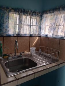 San Lucas SacatepéquezにあるHabitación con cocina - Hacienda Santo Domingoのキッチンシンク(皿棚付)