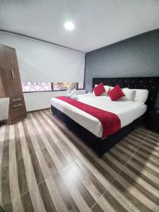 1 dormitorio grande con 1 cama grande con almohadas rojas en AW Hotel American Travel, en Bogotá