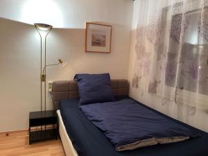 - une chambre avec un lit doté de draps bleus et d'une lampe dans l'établissement Apartment NBG im Zentrum, à Nuremberg