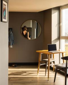 a woman taking a picture in a mirror in a living room at The Gate London City in London