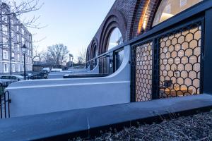 a metal gate on the side of a building at The Arches Luxurious Three Bedroom Houses Close to Hampstead Heath with garden balcony and courtyard in London