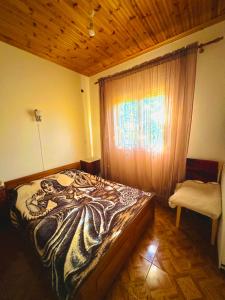 1 dormitorio con cama, ventana y silla en Chalkidiki rent house, en Vergia