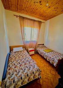 1 dormitorio con 2 camas y ventana en Chalkidiki rent house, en Vergia