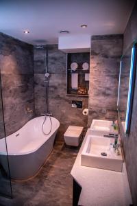 uma casa de banho com uma banheira, um WC e um lavatório. em Golden Tulip Lekki em Lekki