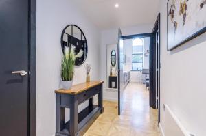 a hallway with a console table and a mirror at Gorgeous Central Flat - Perfect Corporate Stay by PureStay Short Lets in Leeds