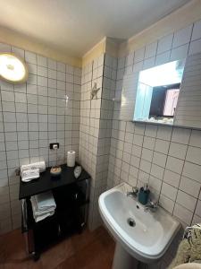 a white bathroom with a sink and a mirror at B&B al Centro del Borgo in Custonaci +8 photos