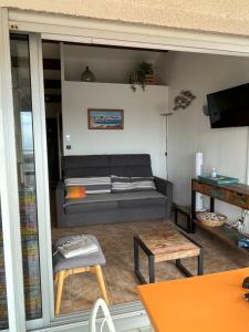 appartement vue mer في كاب داغد: غرفة معيشة مع أريكة وطاولة