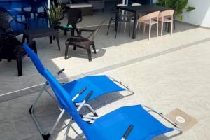 a blue chair sitting on a patio with tables and chairs at Casa Quinta Moderna Piscina Privada En via Girardot in Girardot