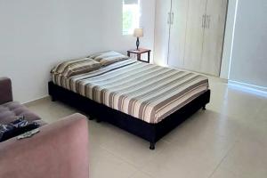 a bedroom with a bed and a couch at Casa Quinta Moderna Piscina Privada En via Girardot in Girardot