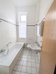 a white bathroom with a tub and a sink at Vakantievilla Rämmen Skola in Rämmen