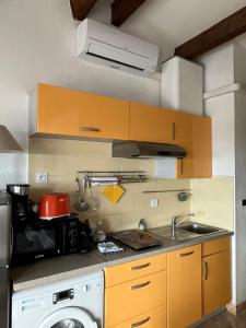 appartement vue mer في كاب داغد: مطبخ مع مغسلة وغسالة ملابس