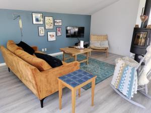 a living room with a couch and a tv at Bright summer house close to the beach and water in Holbæk