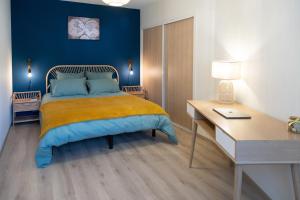 a bedroom with a bed with a desk and a bed sidx sidx sidx at Les Jardins du Pont Rouge - Cosy et Calme in Aurillac