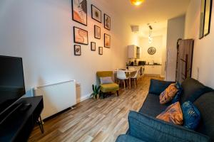 a living room with a blue couch and a kitchen at Converted Chapel Swansea | King Bed | Sleeps 4. in Swansea