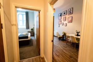 a hallway leading to a room with a bed and a table at Converted Chapel Swansea | King Bed | Sleeps 4. in Swansea