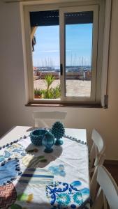 瑪爾薩梅米的住宿－la finestra sul mare a marzamemi，一张桌子,从窗口可欣赏到海景