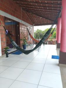 a hammock on a porch of a building at Casa de Temporada de Amaro in Santo Amaro