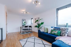 ein Wohnzimmer mit einem blauen Sofa und einem Tisch in der Unterkunft Cohost Partners - Elegant Escape Broadway in Birmingham