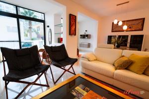 a living room with a couch and two chairs at The Holiday Home Where Art Lives in St Paul's Bay