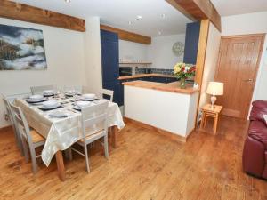 a dining room with a table and a kitchen at Jake’s Cottage - Langrick, Lincolnshire in Boston