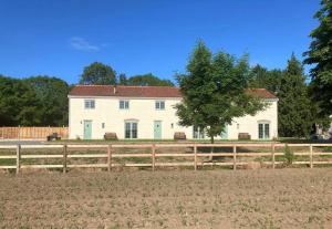 a large white house behind a wooden fence at Jake’s Cottage - Langrick, Lincolnshire in Boston