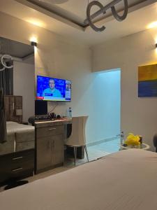 a bedroom with a bed and a tv on a wall at HighX Hotels in Port Harcourt