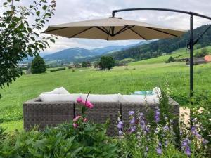 un tavolo da picnic con ombrellone in un campo di Ferienwohnung Scheftenau im Toggenburg a Wattwil