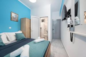 a bedroom with blue walls and a bed and a bathroom at Lefteris Apartment in Kardamaina